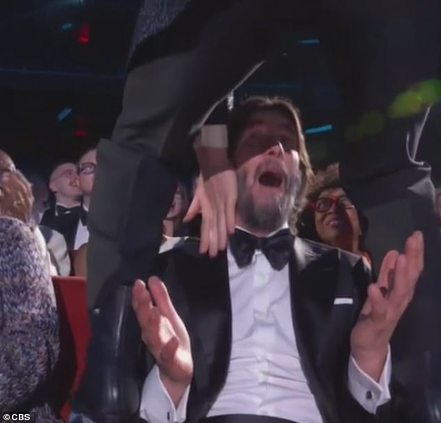 A shocked Reeves screamed before doing a rock on sign, as a cheeky Groff grabbed his chest - before jumping off the chair