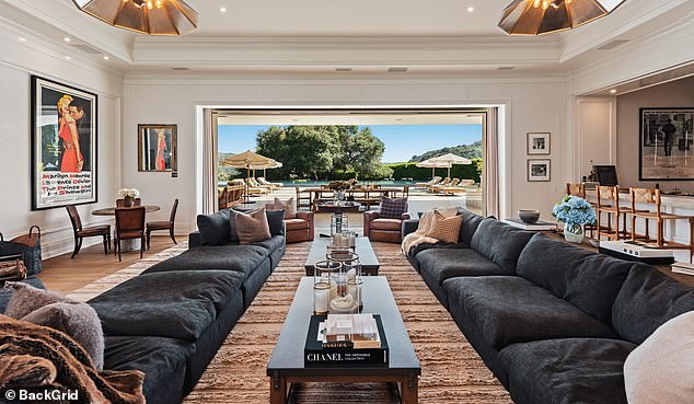 The 38,000 square-foot home features a living room area that extends into a patio, with a view of a $150,000 pool