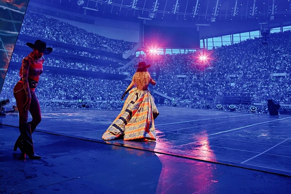 Beyoncé performing on stage at a stadium concert.