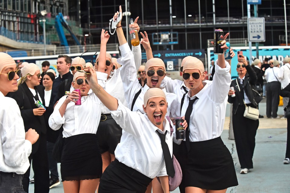 Pitbull fans in Manchester wearing bald caps and white shirts.