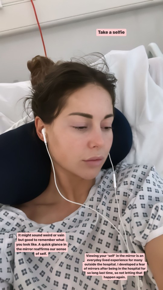 Woman in hospital gown takes selfie.