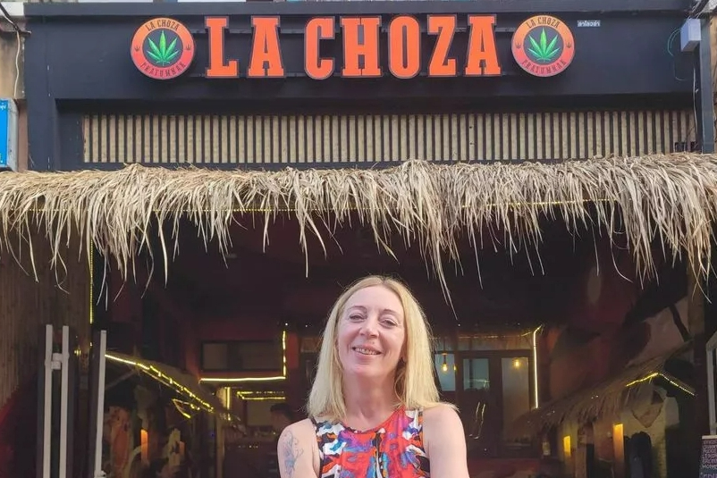 Woman standing in front of La Choza Tradicional bar in Thailand.