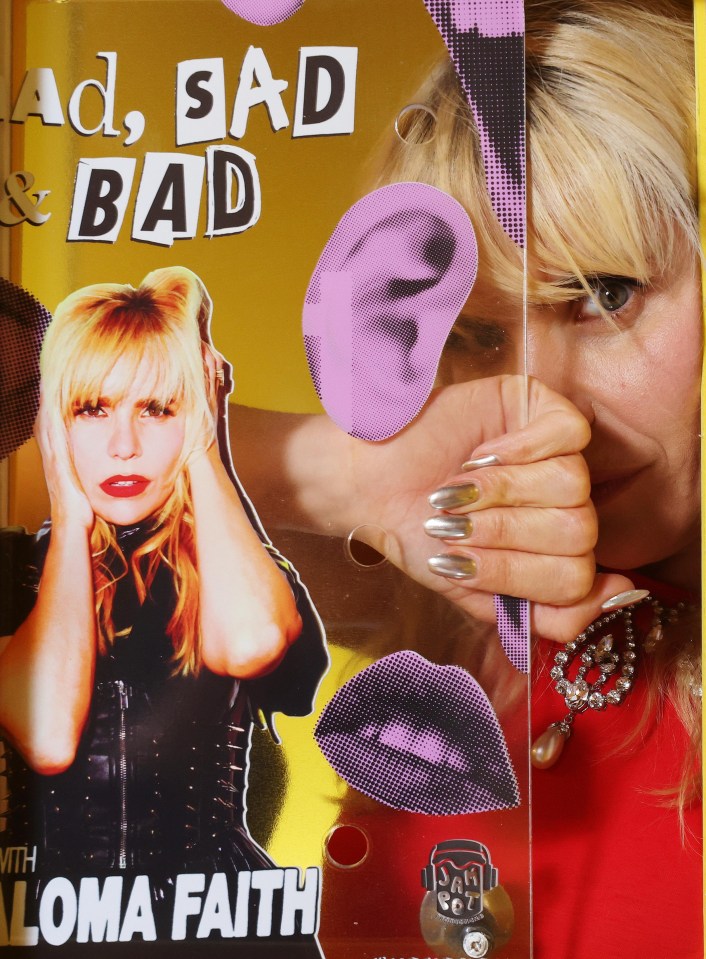 Paloma Faith peeking through a pop-up confession booth promoting her podcast, Mad, Sad & Bad.