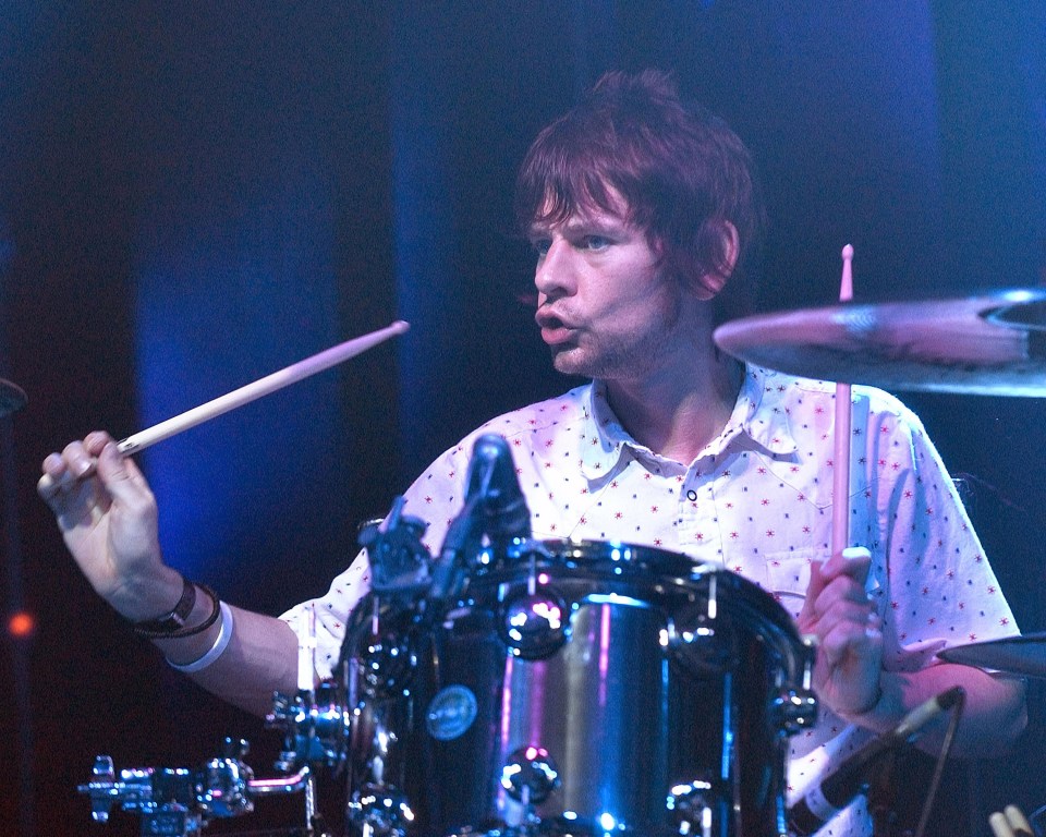 Zak Starkey of Oasis playing the drums at a concert.
