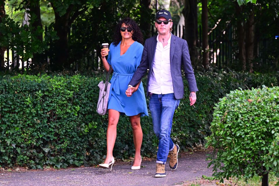Laurence Fox and Elizabeth Barker holding hands and walking.