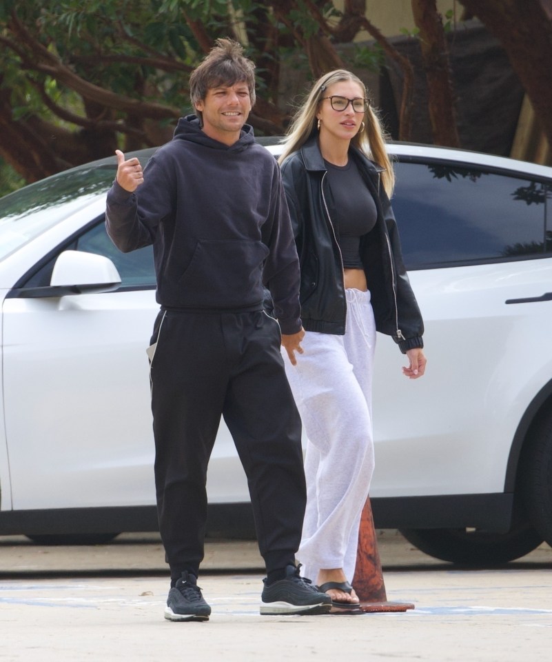Louis Tomlinson and Zara McDermott holding hands.