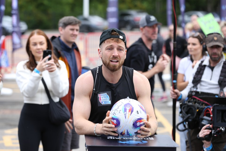 Sam Thompson holding a signed soccer ball after completing his Match Ball Mission for Soccer Aid UNICEF.