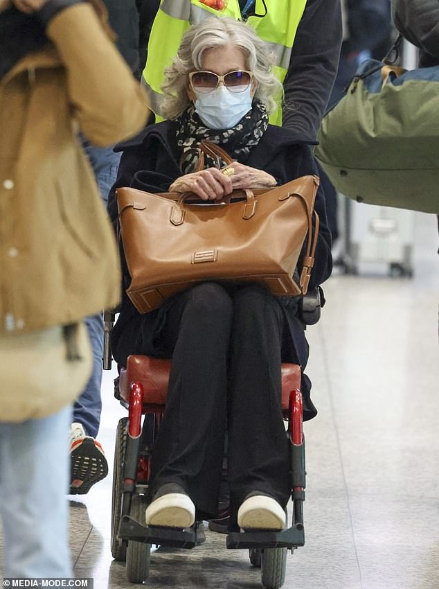 She accessorised with a designer tan leather handbag perched on her lap