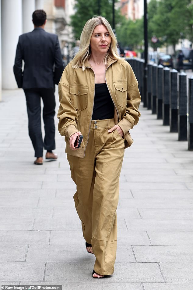 The singer layered a skin-tight black vest underneath her jacket and added inches to her frame with black open-toe heels