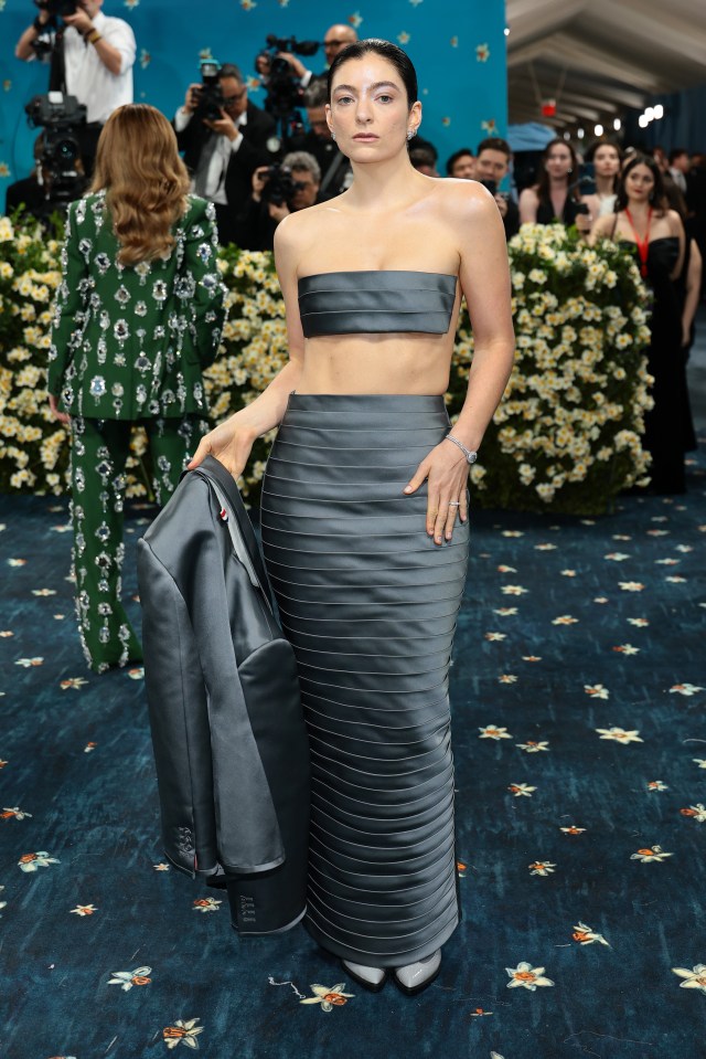 Lorde at the Met Gala in a gray crop top and skirt.