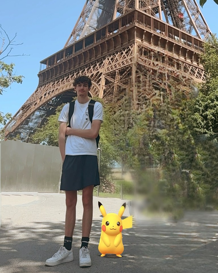 Person standing in front of the Eiffel Tower with a Pikachu.