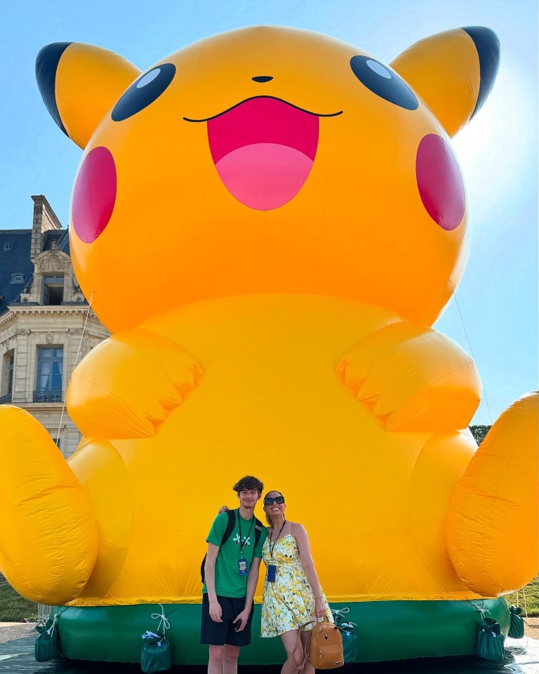 Two people standing in front of a giant inflatable Pikachu.