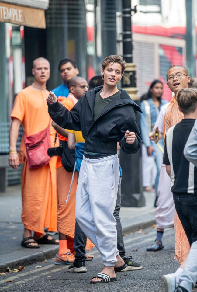 a group of people are walking down a street in front of a sign that says temple
