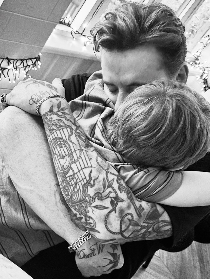 Black and white photo of a father hugging his son.