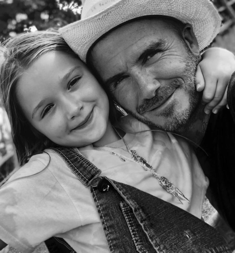 Black and white photo of David Beckham hugging his daughter.