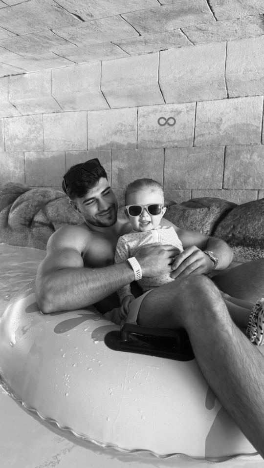A man and a toddler wearing sunglasses on a water ride.