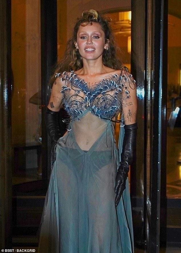 The singer, 32, went braless in an ethereal sheer gown that featured peacock feathers across her chest