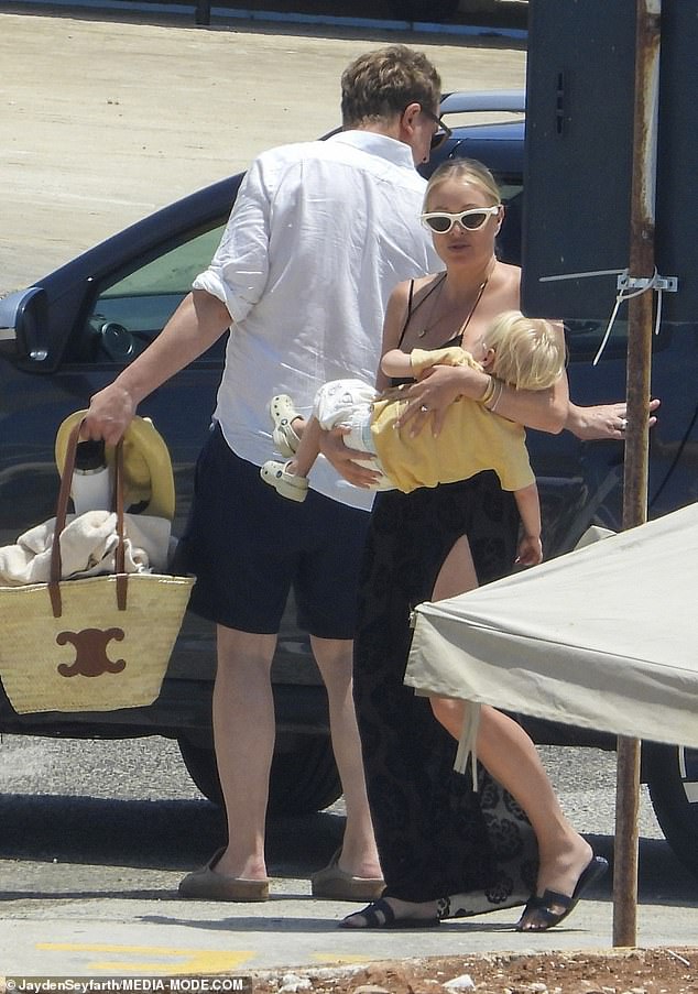 She looked every inch the doting mum as she carried her two-year-old son Peter in her arms