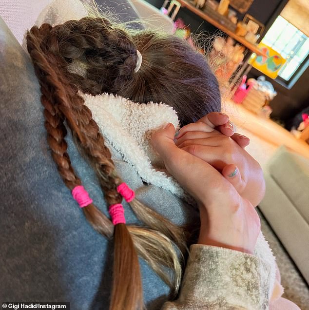 Hadid's mini-me rocked a triple-braided ponytail while holding hands with her on a couch in another snap
