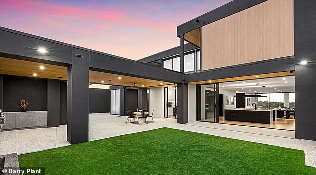 Constructed on what was once a cow paddock, the steel and glass home features soaring ceilings and dramatic design features, including a Lucretia crystal chandelier