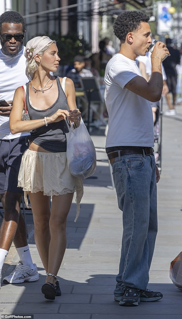 Iris dressed for the hot weather last week as she stepped out in a dark grey vest top with a white lace bra
