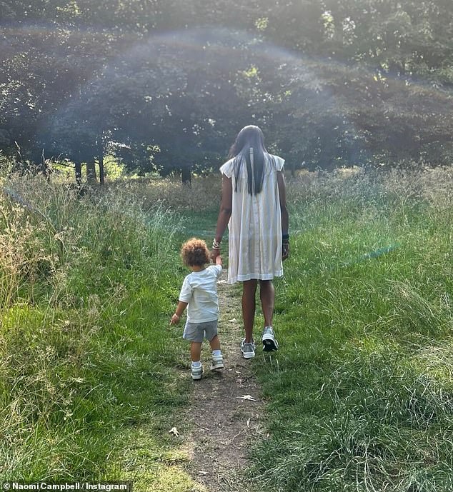 Taking to Instagram on Monday, Naomi was seen wearing a white smock dress, while holding hands with her two little ones as they strolled through the woods and went tree hugging together