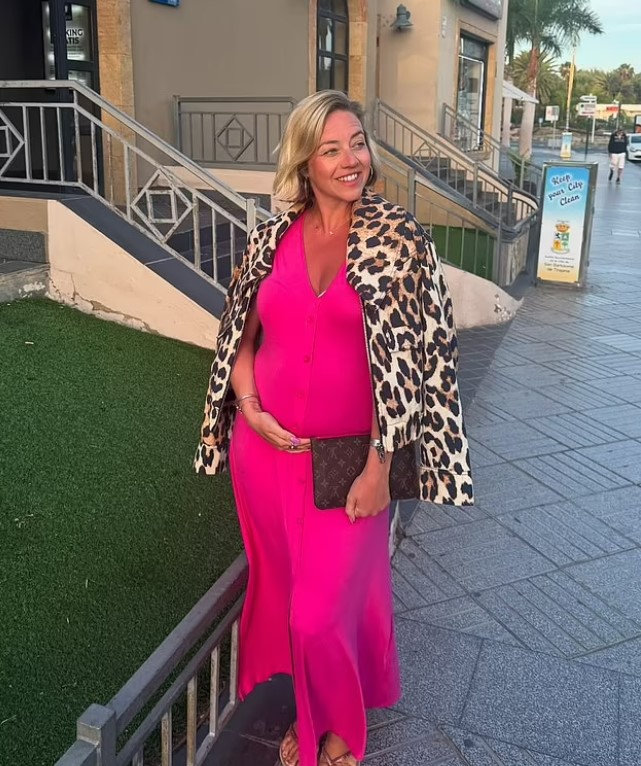 Pregnant woman in pink dress and leopard print jacket.