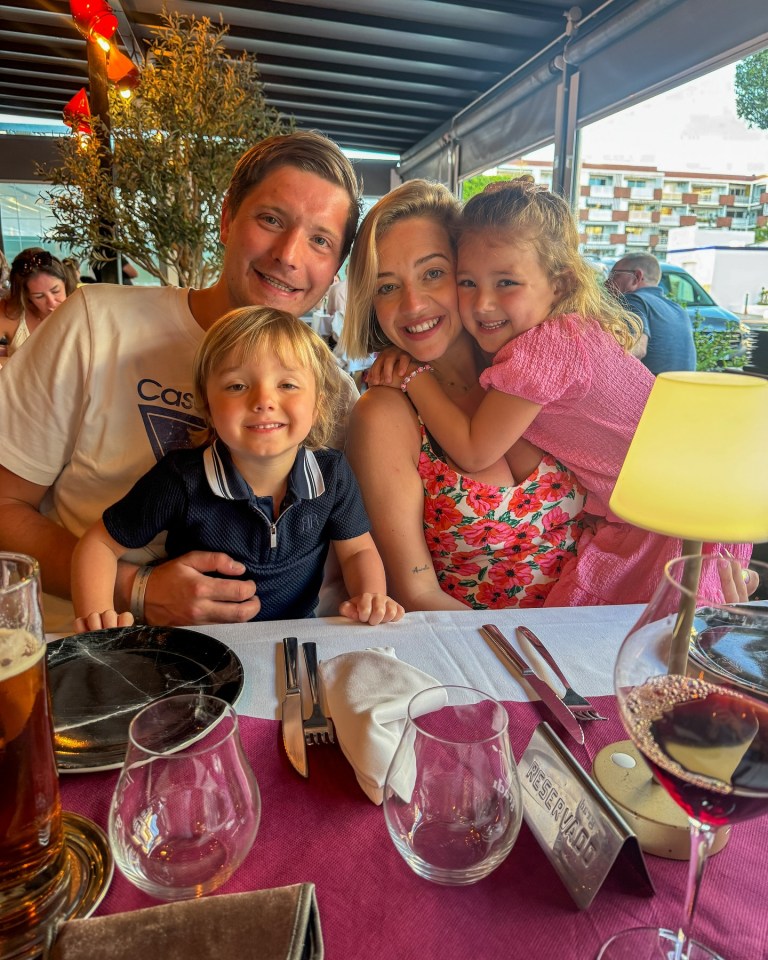 Family of four sitting at a restaurant table.