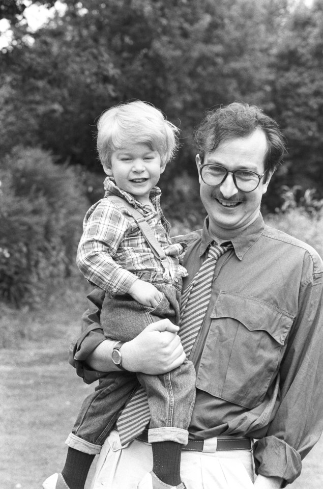 Black and white photo of Steve Wright, a BBC radio DJ, holding his son.