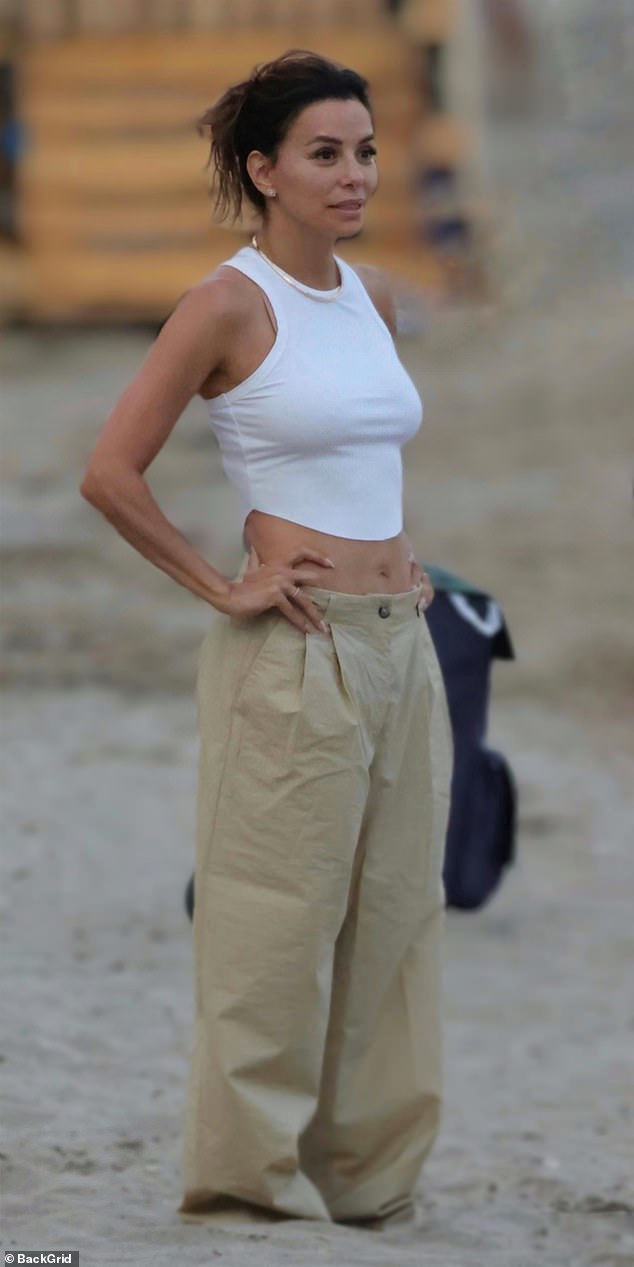Showing off her toned tummy, Eva paired her white crop top with low-rise, beige baggy trousers for a relaxed yet stylish look