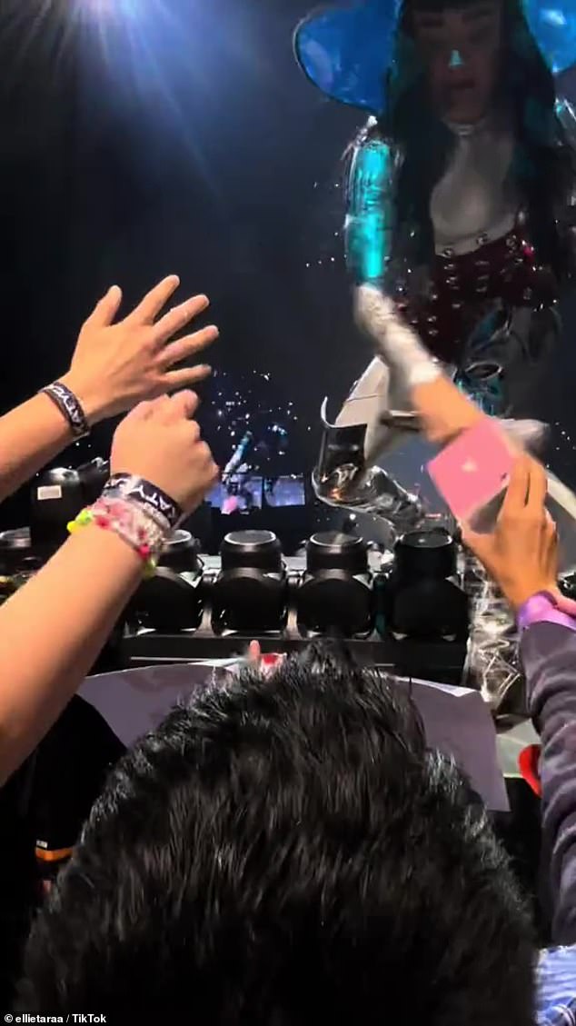 The American pop star, 39, was captured on TikTok marching towards fans mid-song while carrying a tray of Tim Tams during a performance of her emotional ballad, I'm Still Breathing