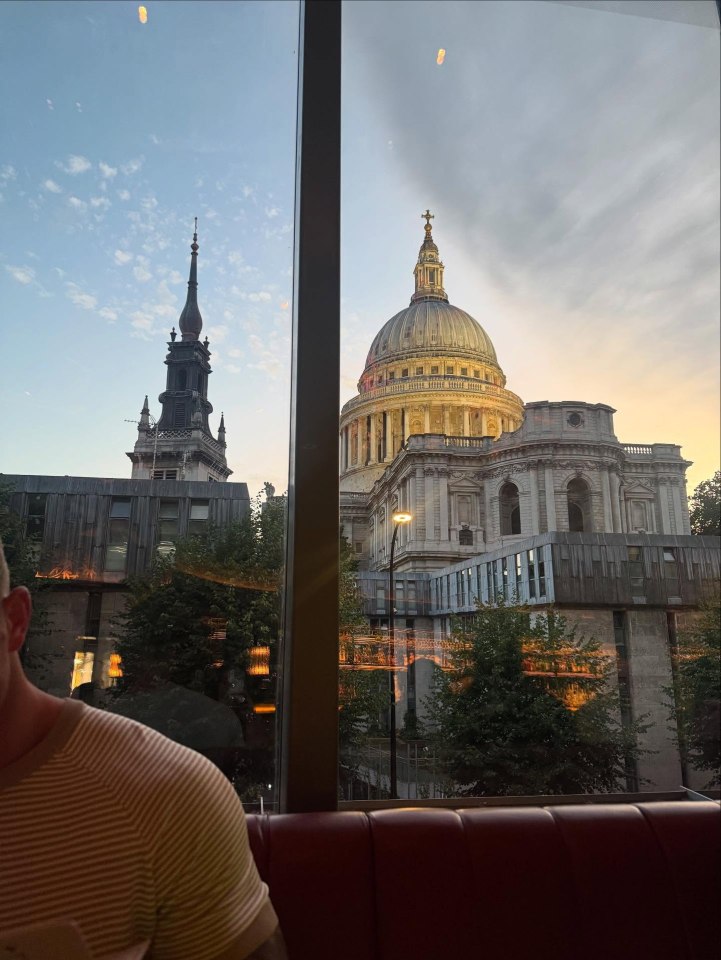 View of St. Paul's Cathedral and another church steeple from inside a building.