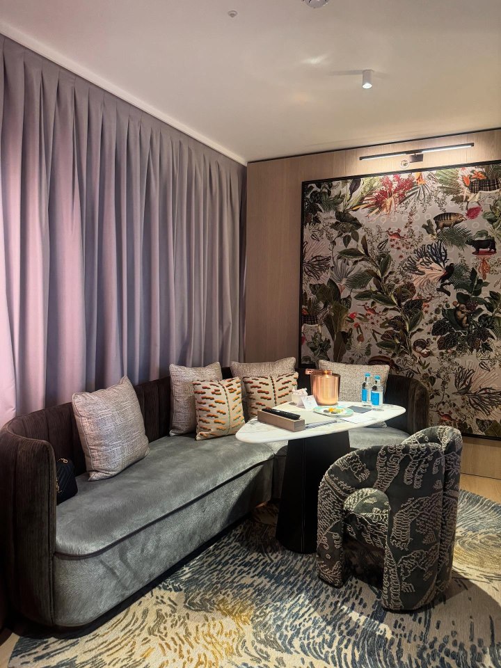 Hotel suite sitting area with sofa, chair, and coffee table.