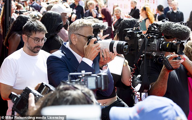 The award winning actor blended in with photographers as he borrowed a camera