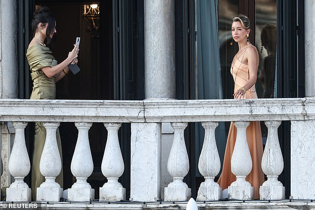 Another guests takes a snap of Ms Kives as she poses in a stunning peach coloured gown