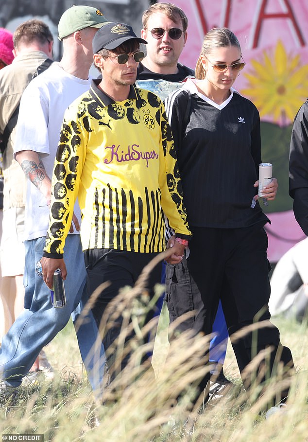 Louis wore a graphic football shirt which he teamed with black cargo trousers and shielded his famous features beneath shades and a baseball cap