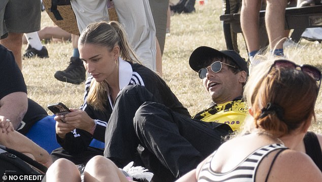 They later sat together on the grass as they enjoyed the music