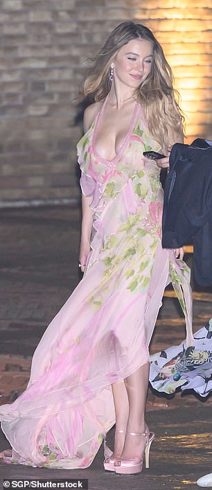 She added a few extra inches to her frame with a pair of pink satin heels and let her outfit do all the talking as she exited the glitzy venue