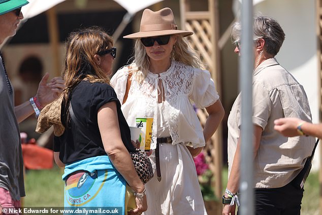 After disembarking the helicopter, Holly wasted no time kickstarting the three-day spectacular in Somerset, as she strolled around the grounds with a friend
