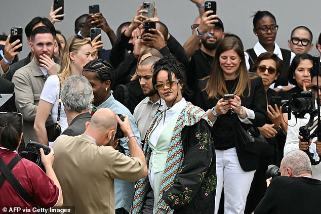She teamed this with a patterned blue scarf, a black floral jacket, a pearl choker and orange tinted shades