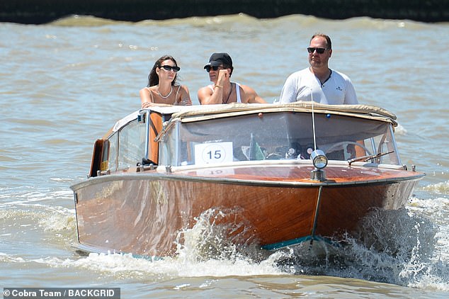 The model added a pair of trendy black sunglasses, and was spotted standing at the back of the boat as it sped to the mainland, chatting to Orlando