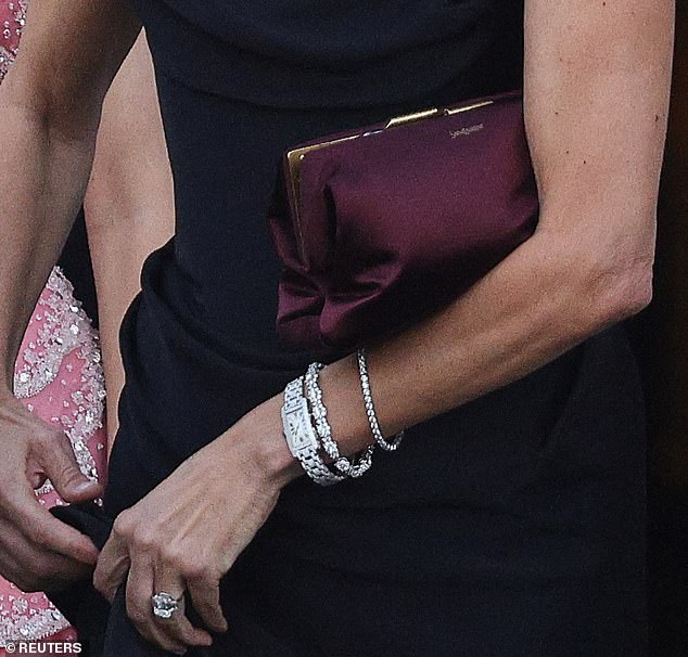 She wore a Cartier diamond watch on her wrist which retails for around $100,000, alongside several diamond bracelets. She also held a $4080 satin Saint Laurent clutch