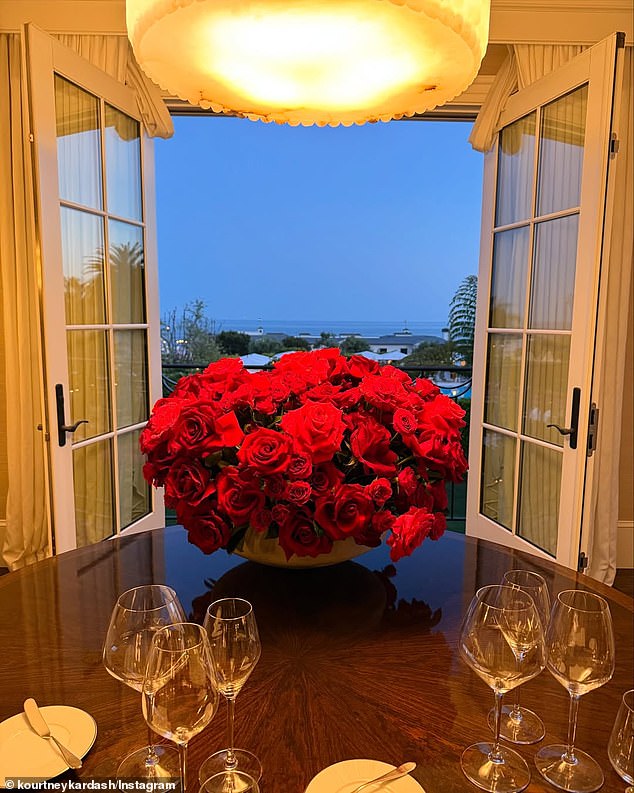 She also posted another lavish display of red roses at the center of their dinner table, in front of open doors that framed the stunning oceanfront scenery