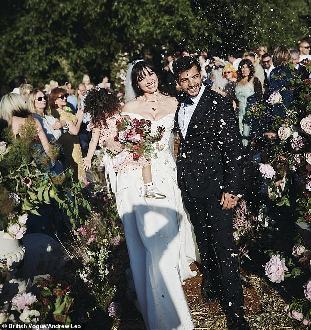 Blushing bride Daisy Lowe cradled her daughter Ivy as she walked down the aisle with new husband Jordan Saul in striking new wedding snaps