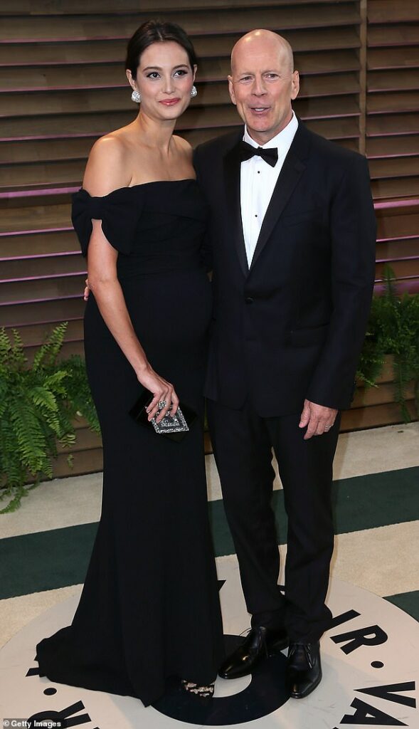 Bruce Willis ’ wife Emma Heming is opening up for the first time about how the action legend continued working on film sets even as his health quietly declined behind the scenes; (Bruce and Emma in 2014)