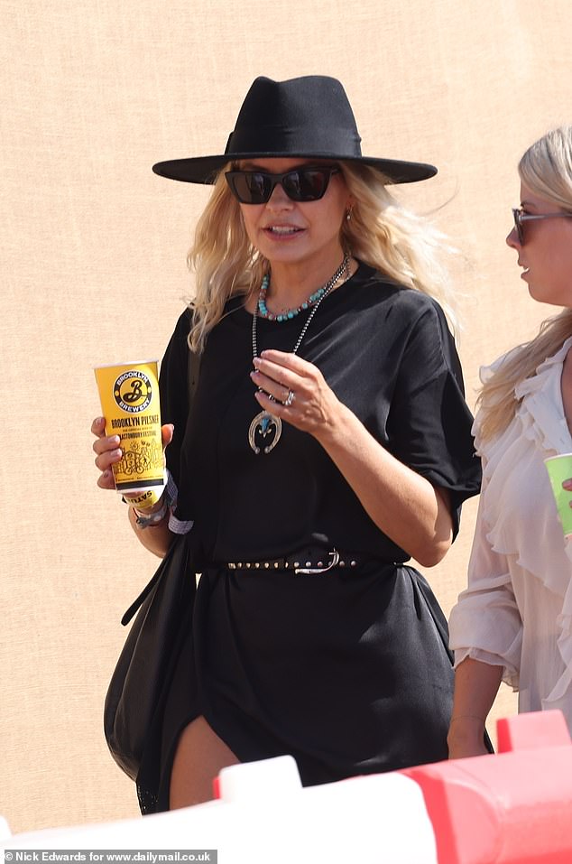 The TV personality put on a very leggy display in a black lace mini dress which she teamed with chunky boots as she was spotted strolling around Worthy Farm