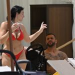 Annie Kilner, 32, showing off her stunning figure in a red bikini as she sipped an iced drink next to Kyle Walker, 34, at the Orlando theme park resort