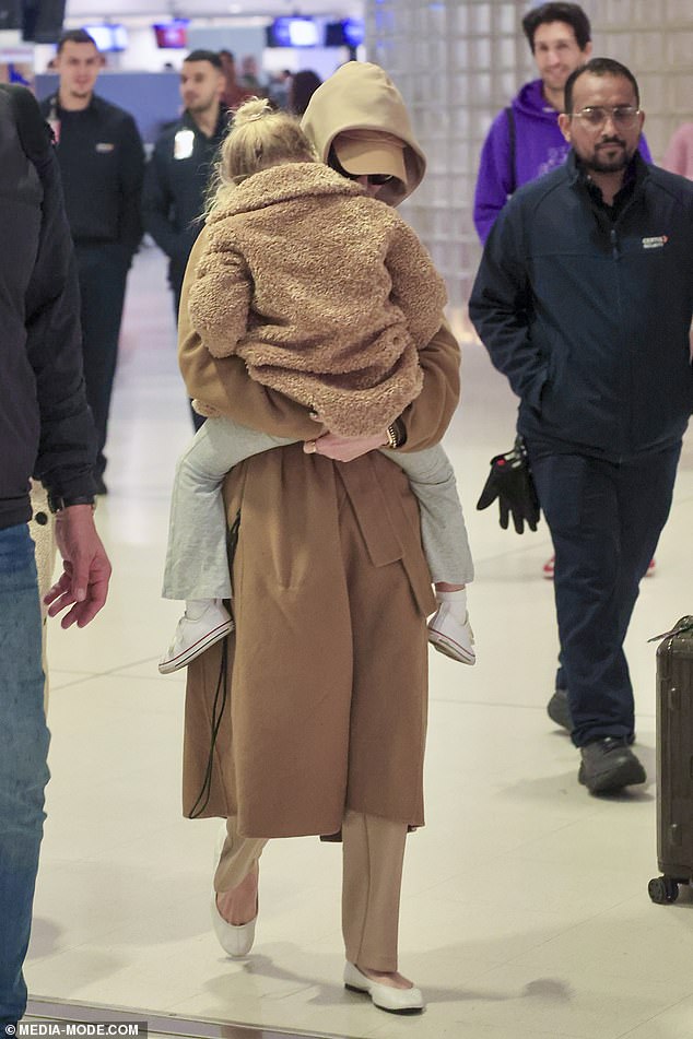 She had on trousers in the same caramel colour palette as the rest of her ensemble, as well as a pair of comfortable white ballerina slippers