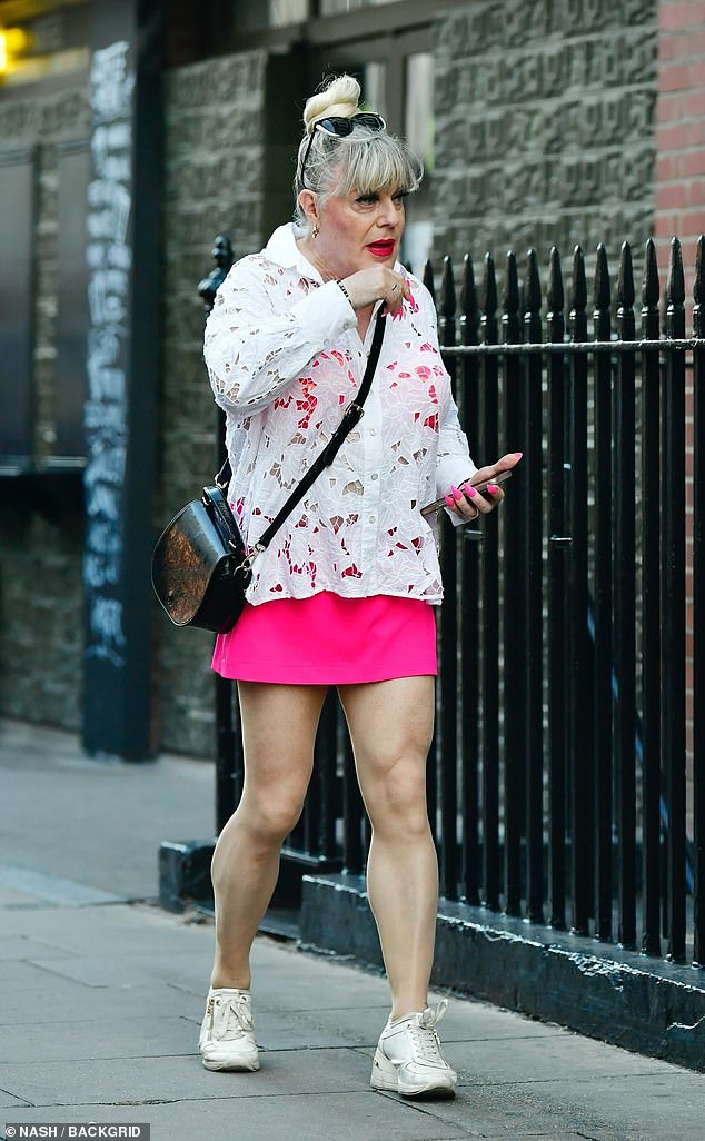 Teaming her skirt with a white blouse, she finished her look with white trainers and a black leather cross-body bag