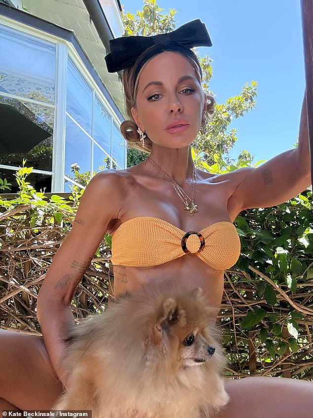 In another snap, Kate was seen sporting an orange ribbed bandeau bikini top as he dog sat on her lap